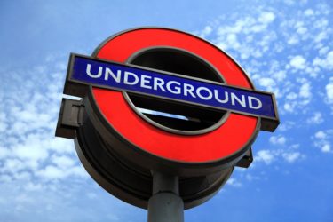 A photo of the London Underground signage against a blue sky backdrop