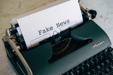 A type-writer and paper - the words on the paper read "Fake News!"