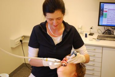A dentist works on a patient's teeth - image by Erik Christensen (CC BY-SA 3.0)