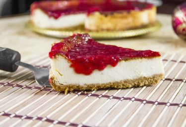 A slice of strawberry topped cheesecake