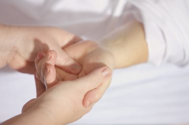 A therapist holding the hand of a patient