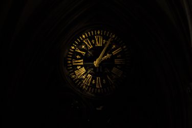 A clock face with roman numerals on a black background
