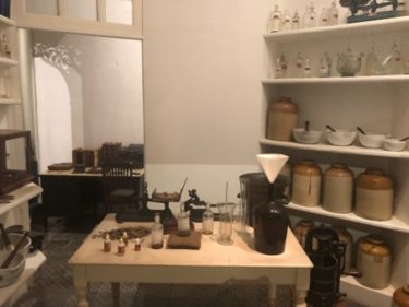 The first homeopathy pharmacy in Brazil, which was gifted to Brazil's national museum - many shelves with jars and bottles stand behind a table laden with small bottles as if ready to be filled.