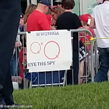 A QAnon poster on a fence with the letters "WWG1WGA" which stands for where we go one, we go all. [CC 2.0]