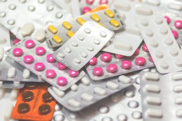 An assortment of blister packets containing different shaped and coloured tablets. 