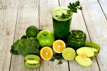 A green smoothie and lots of green fruit and vegetables