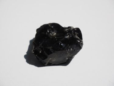 An obsidian crystal on a white background