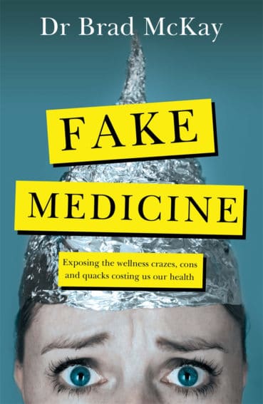 The cover of Dr Brad McKay's book: Fake Medicine. The cover has a blue gradient background with a photo of a worried looking person wearing black eye make up and a tin foil hat. Over the top of the photo is black text on a yellow box background with the words "Fake Medicine" and "Exposing the wellness crazes, cons and quacks costing us our health".