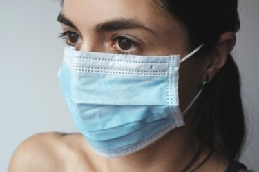 A woman wearing a surgical face mask