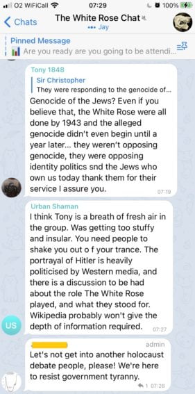 An exchange in "The White Rose Chat" (6,912 members, 818 online). 

The first message has user Tony 1848 comment on a previous off-screen message about the holocaust: "Genocide of the Jews? Even if you believe that, the White Rose were all done by 1943 and the alleged genocide didn’t even begin until a year later… they weren’t opposing genocide, they were opposing identity politics and the Jews who own us today thank them for their service, I assure you."

The second message has user Urban Shaman respond "I think Tony is a breath of fresh air in the group. Was getting too stuffy and insular. You need people to shake you out of your trance. The portrayal of Hitler is heavily politicised by Western media."

The final message has a channel moderator respond "Let's not get into another holocaust debate people, please! We're here to resist government tyranny"