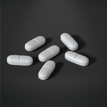 six white tablets on a grey background