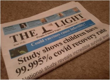 A photo of a copy of The Light folded to show just the headline "Study shows chuidren have 99.995% covid recovery rate"