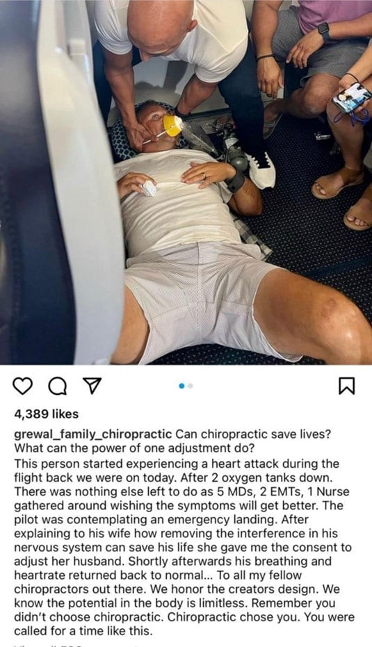 A patient laying on their back with their eyes open in an airplane. He's wearing an oxygen mask, white t shirt and light coloured shorts. On his right ring finger is a pulse oximeter and a man crouches over his head with his hands on either side of his head/neck. 

The photo is a screen shot of an instagram post, the caption reads "grewal_family_chiropractic Can chiropractic save lives? What can the power of one adjustment do? This person started experiencing a heart attack during the flight back we were on today. After 2 oxygen tanks down. There was nothing else left to do as 5 MDs, 2 EMTs, 1 Nurse gathered around wishing the symptoms will get better. The pilot was contemplating an emergency landing. After explaining to his wife how removing the interference in his nervous system can save his life she gave me the consent to adjust her husband. Shortly afterwards his breathing and heartrate returned back to normal... To all my fellow chiropractors out there. We honor the creators design. We know the potential in the body is limitless. Remember you don't choose chiropractic. Chiropractic chose you. You were called for a time like this."