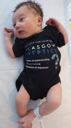 A baby sporting a Glasgow Skeptics baby grow