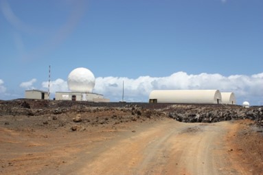 US tracking station at Comfortless Cove - large white buildings beyond a dusty road track