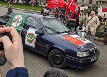 Piers Corbyn in a car with posters all over it. 

Source: Brian Eggo