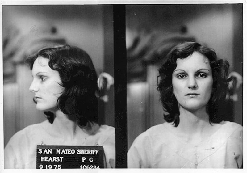 A black and white mugshot of Patty Hearst. She is a slim woman with dark curly hair and fair skin. 

From Flickr https://www.flickr.com/photos/simonm1965/6106751150

CC BY-NC 2.0 DEED
Attribution-NonCommercial 2.0 Generic