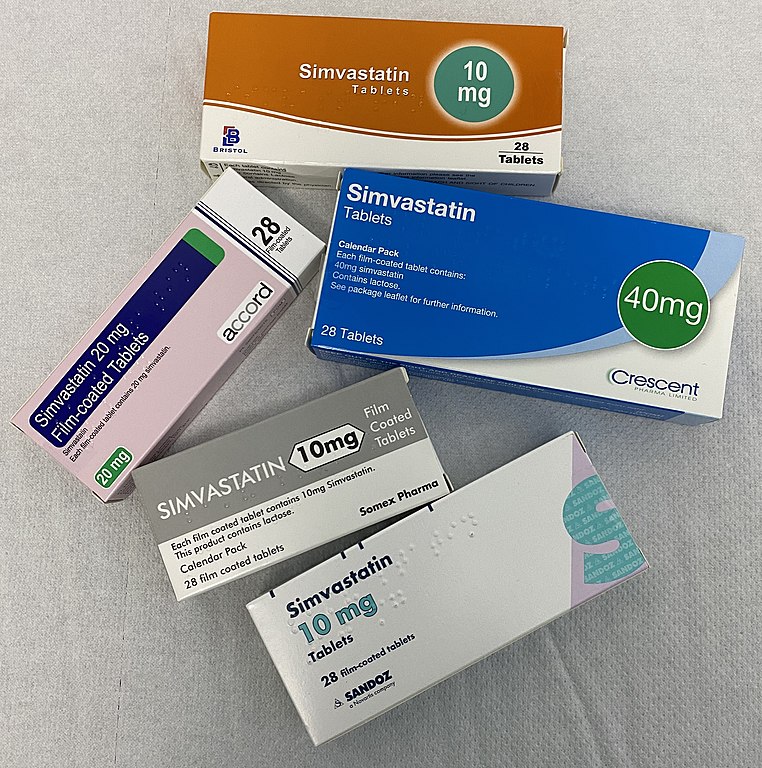 Five varieties of simvastatin tablets laid out on a grey-brown paper towel. Each box is branded differently. Three are 10mg per tablet, one is 20mg and one 40mg.