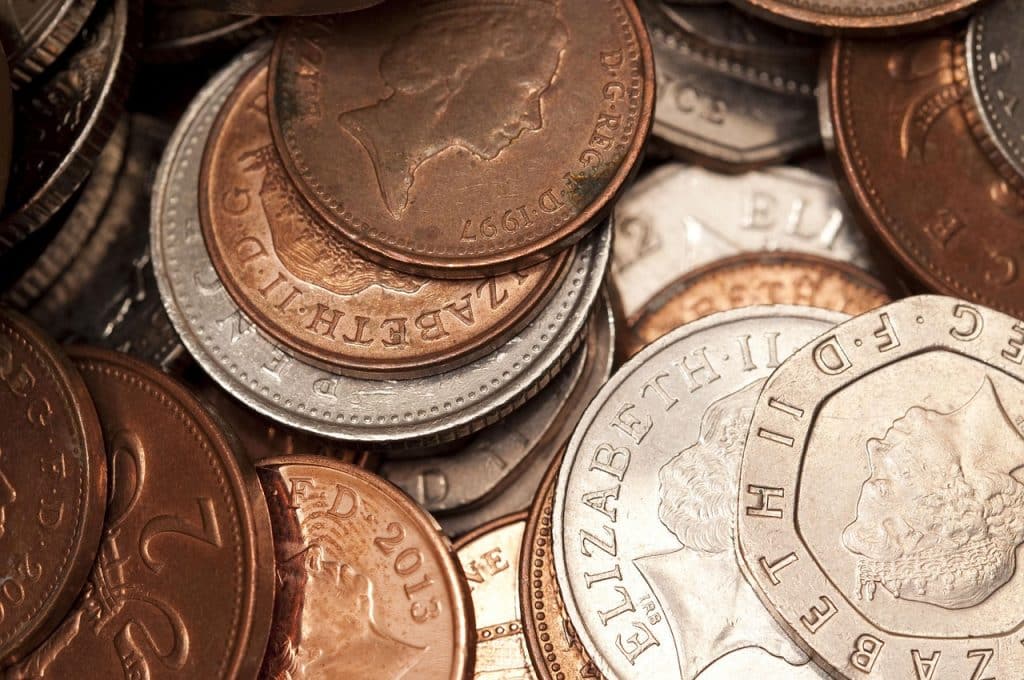 A close-up of a pile of British pence coins mainly of values 1p, 10p and 20p.