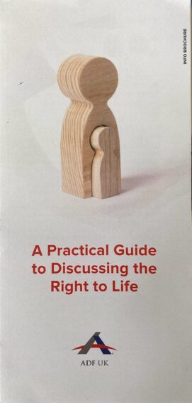 Front of an Alliance Defending Freedom (ADF) pamphlet, 'A Practical Guide to Discussing the Right to Life'. Featuring an image of a simplified, pawn-like wooden person-figure, which has a smaller figure emerging horizontally from its body. The ADF UK logo is below.