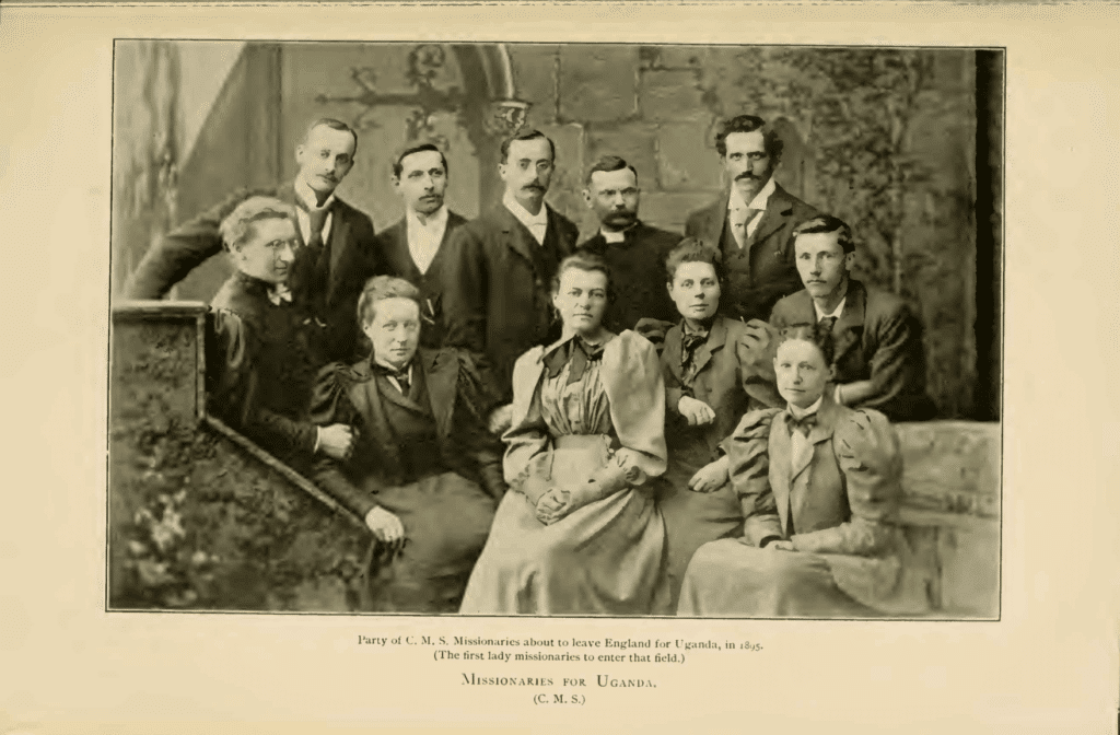 Sepia photograph titled “Missionaries for Uganda. Party of C.M.S Missionaries about to leave England for Uganda, in 1895. (the first lady missionaries to enter that field.)" Six white men in suits stand behind five seated white women, all wearing formal Victorian era dress. 