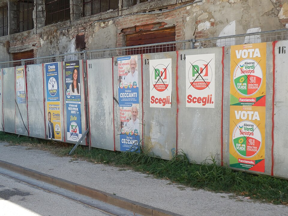A wall on which 11 Italian-language political posters have been pasted