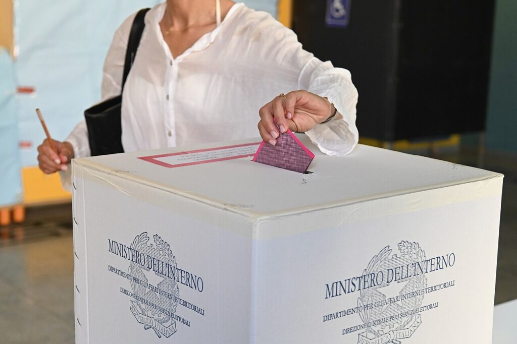  A woman places a ballot paper into a ballot box marked "Ministero dell'interno"