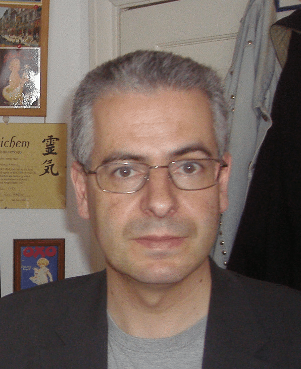 A photograph of a white man with short grey hair looking directly at the camera.