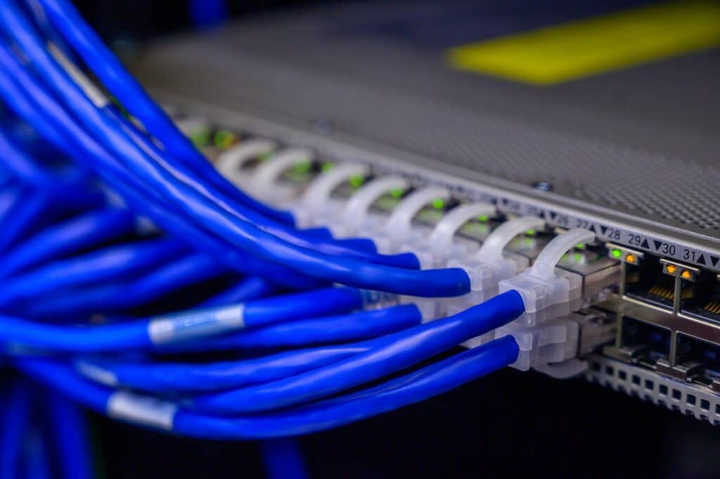 Many ethernet cables plugged into network equipment.