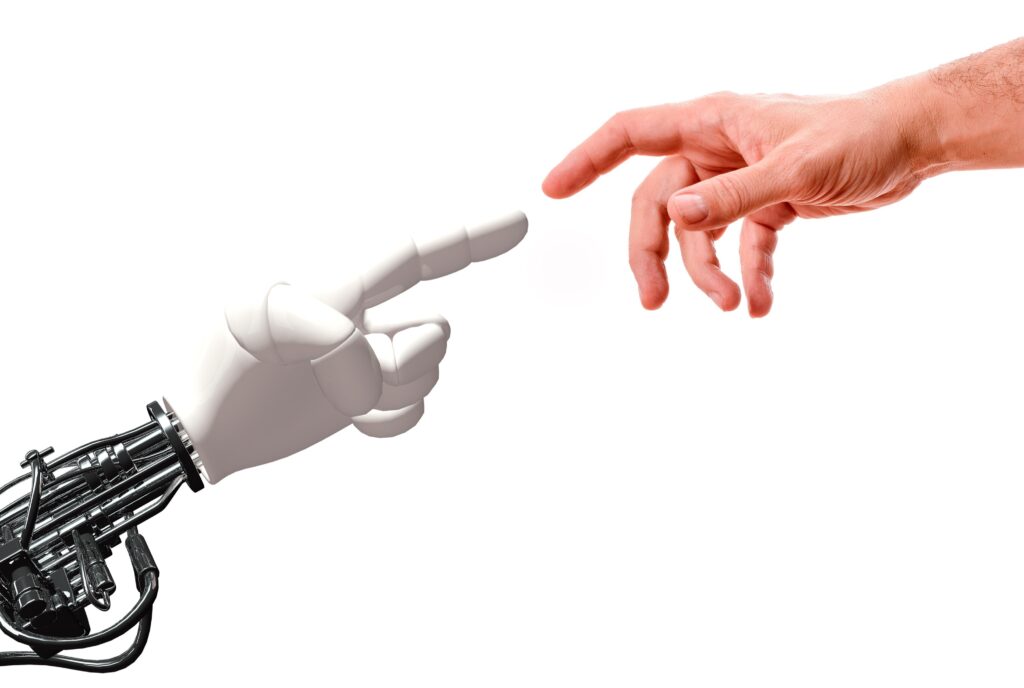 A digital illustration of a white prosthetic hand attached to black cables and mechanisms points upwards and to the right with its index finger extended, with a white man's hand reaching down towards it from the top right (imitating Michaelangelo's Adam/God artwork)