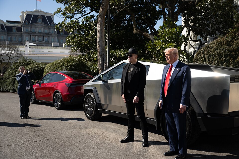 Photograph of Donald Trump and Elon Musk standing beside a Tesla cybertruck, just outside the White House.