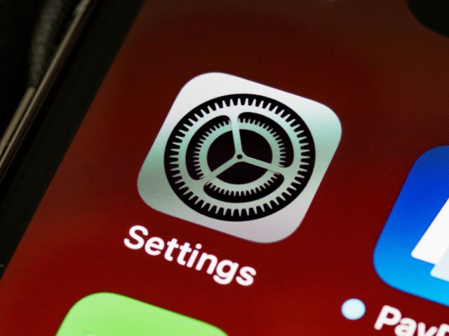 Photograph of the "Settings" icon on an iPhone screen.